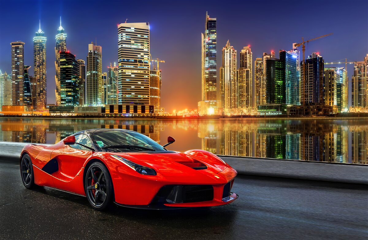 Fototapeta samochód sportowy z nocnym pejzażem miejskim w tle